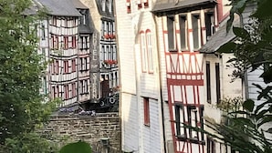 Un edificio tradicional europeo con fachada de piedra y estructura de madera, probablemente un hotel o casa de huéspedes histórico.