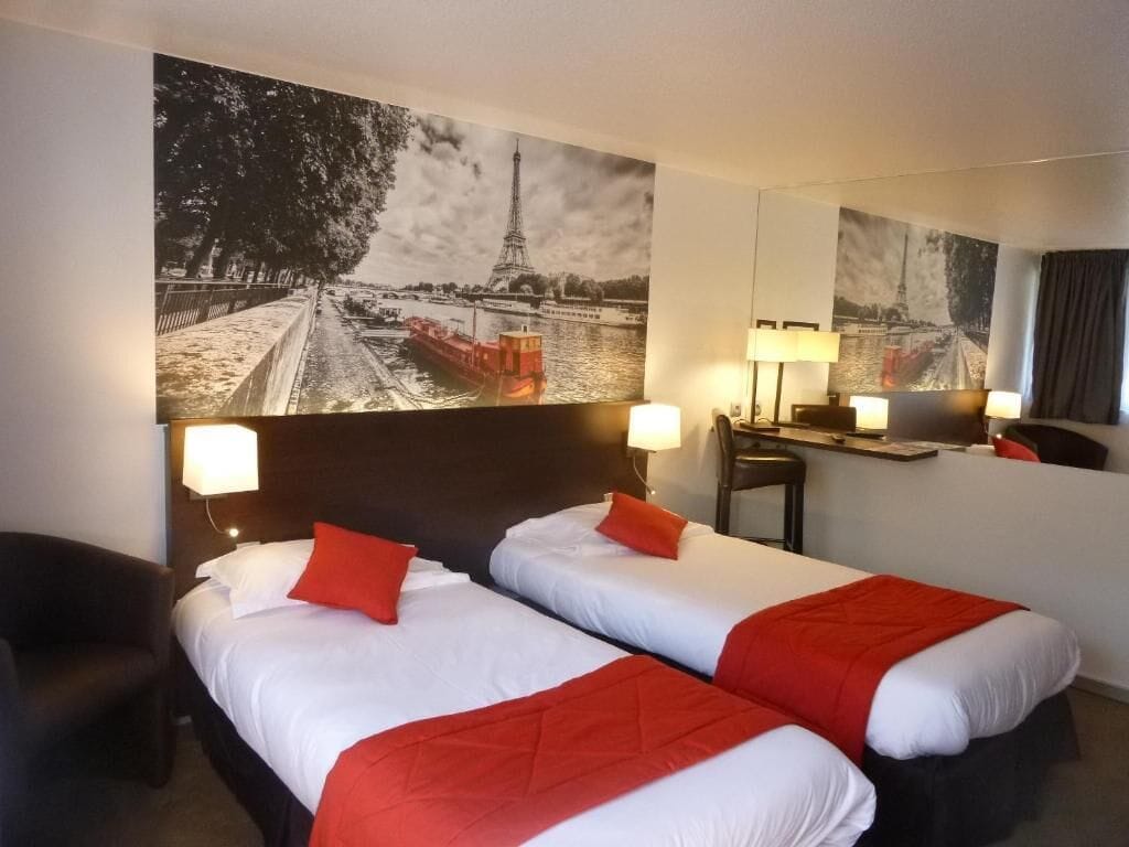 Une chambre d’hôtel avec deux lits, un bureau et une chaise.