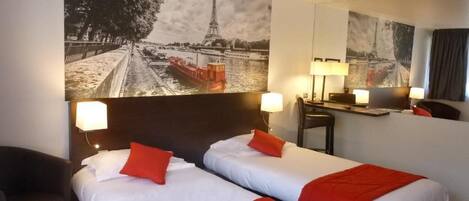 A hotel room with two beds, a desk, and a chair.