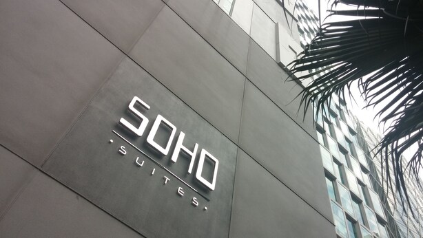 Ein Gebäude mit einem Schild, auf dem „SOHO SUITES“ steht.