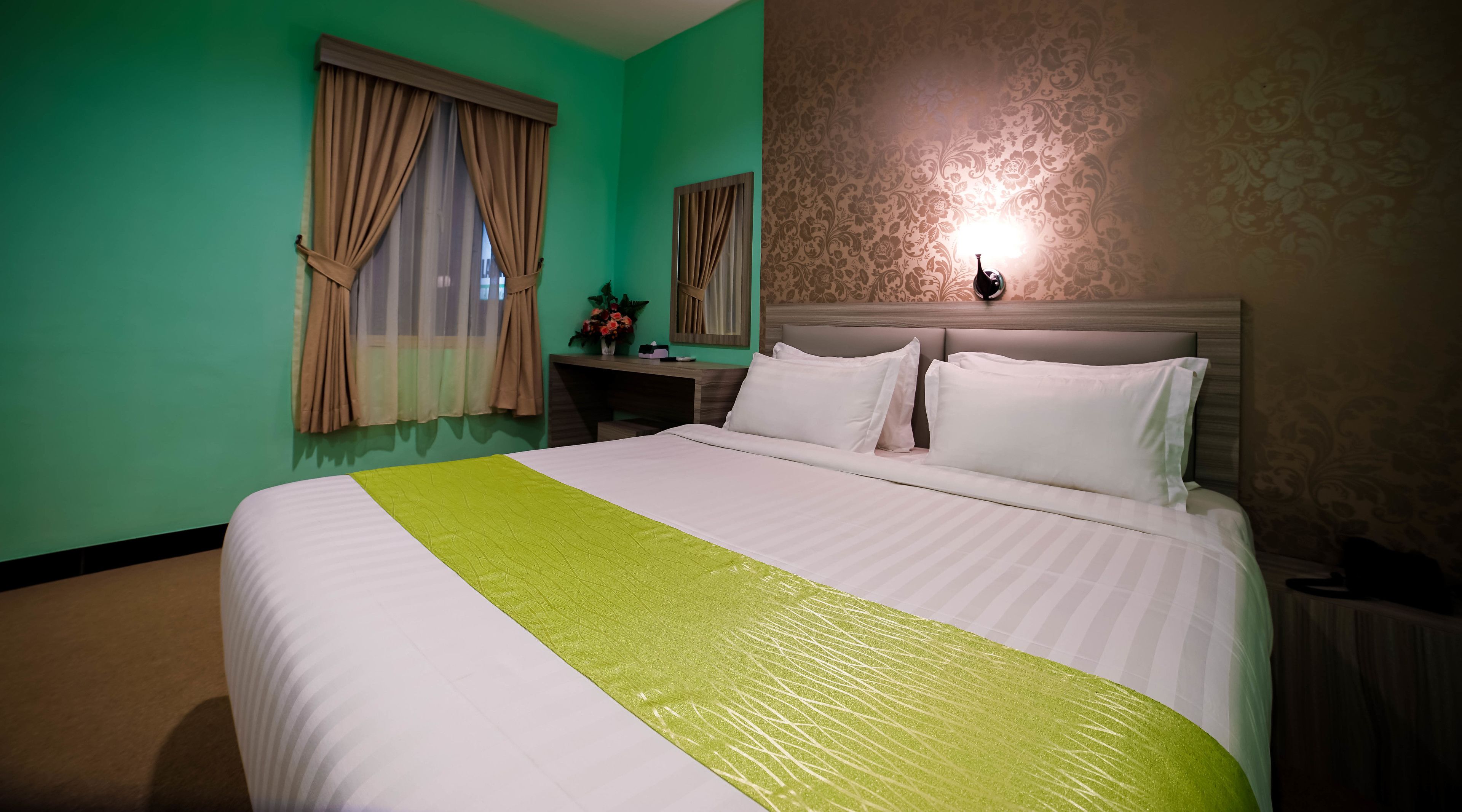 Ein Hotelzimmer mit Bett, Schreibtisch und Lampe.