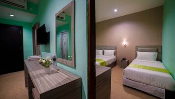 A hotel room with a bed, bedside table, and a mirror.