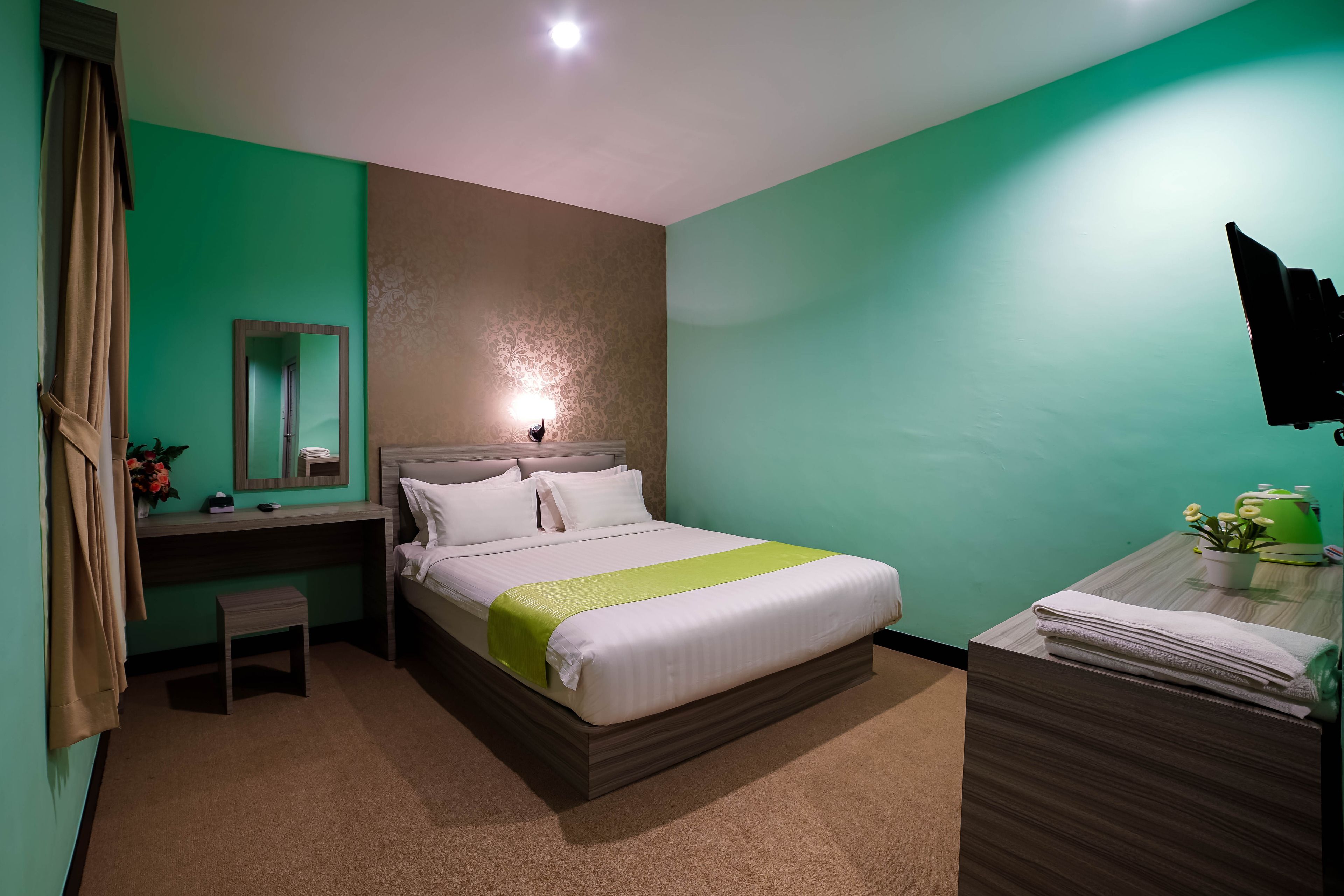 Una habitación de hotel con cama, mesita de noche y escritorio con silla.