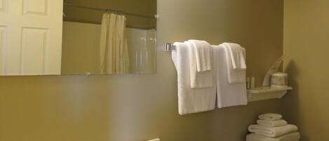 Een badkamer met een wastafel, spiegel, handdoekhouder en toilet.