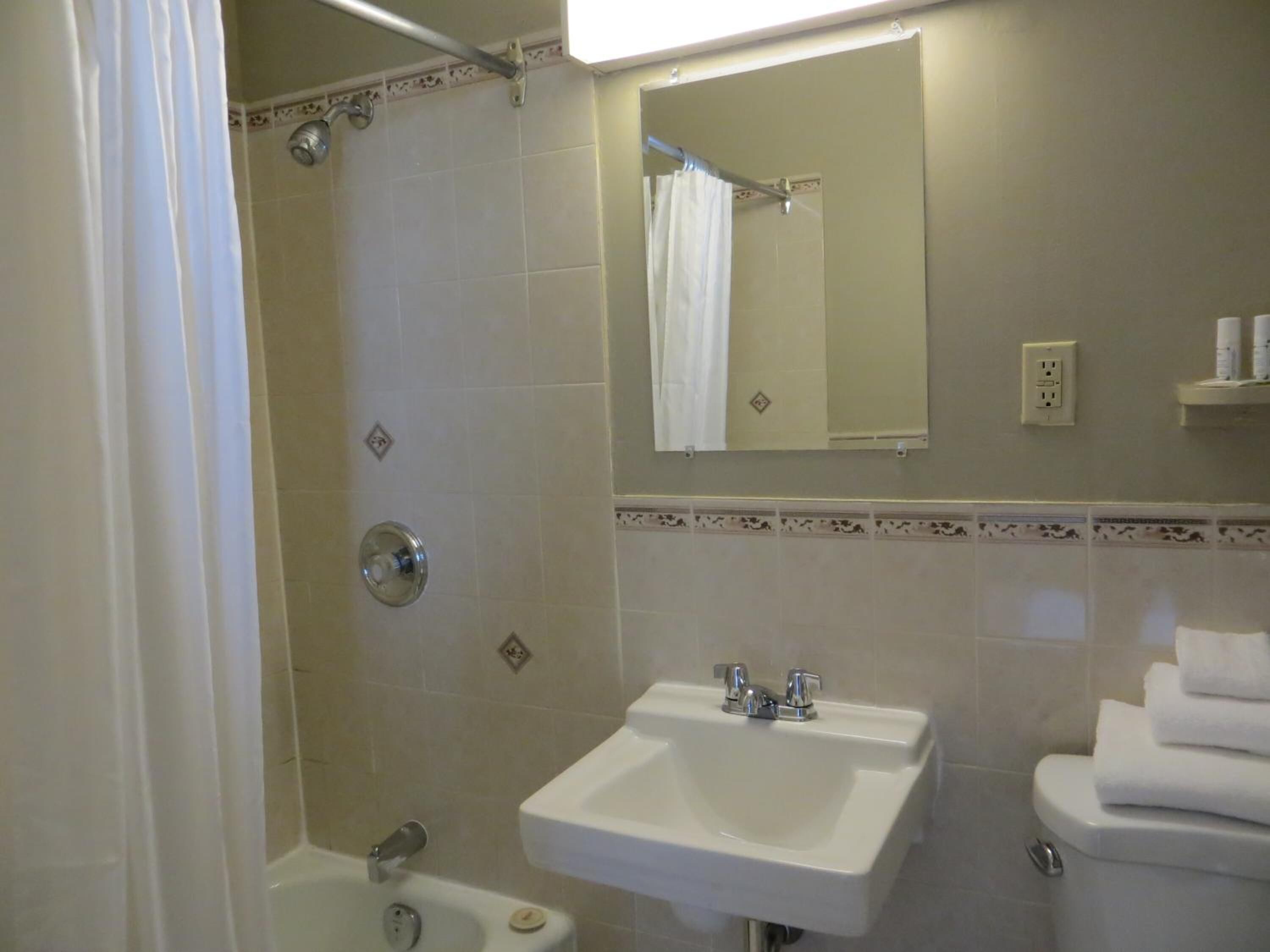 Ein Badezimmer mit Badewanne, Waschbecken, Toilette und Spiegel.