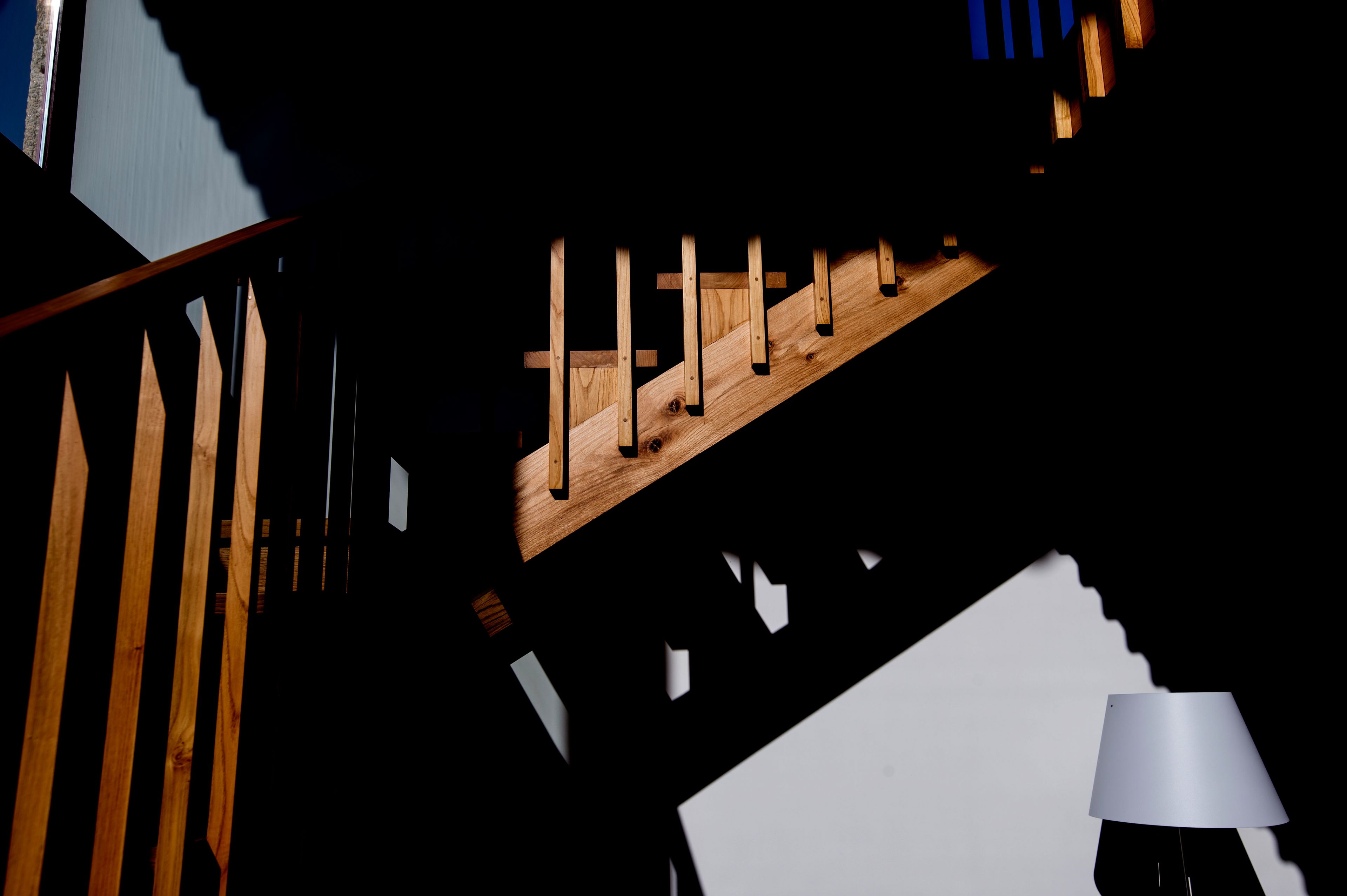 Una escalera con escalones de madera y pared blanca.