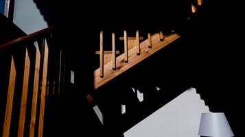 Una escalera con escalones de madera y pared blanca.