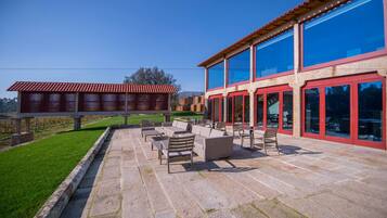 Un patio con mobiliario exterior y vistas a un edificio moderno con amplios ventanales.