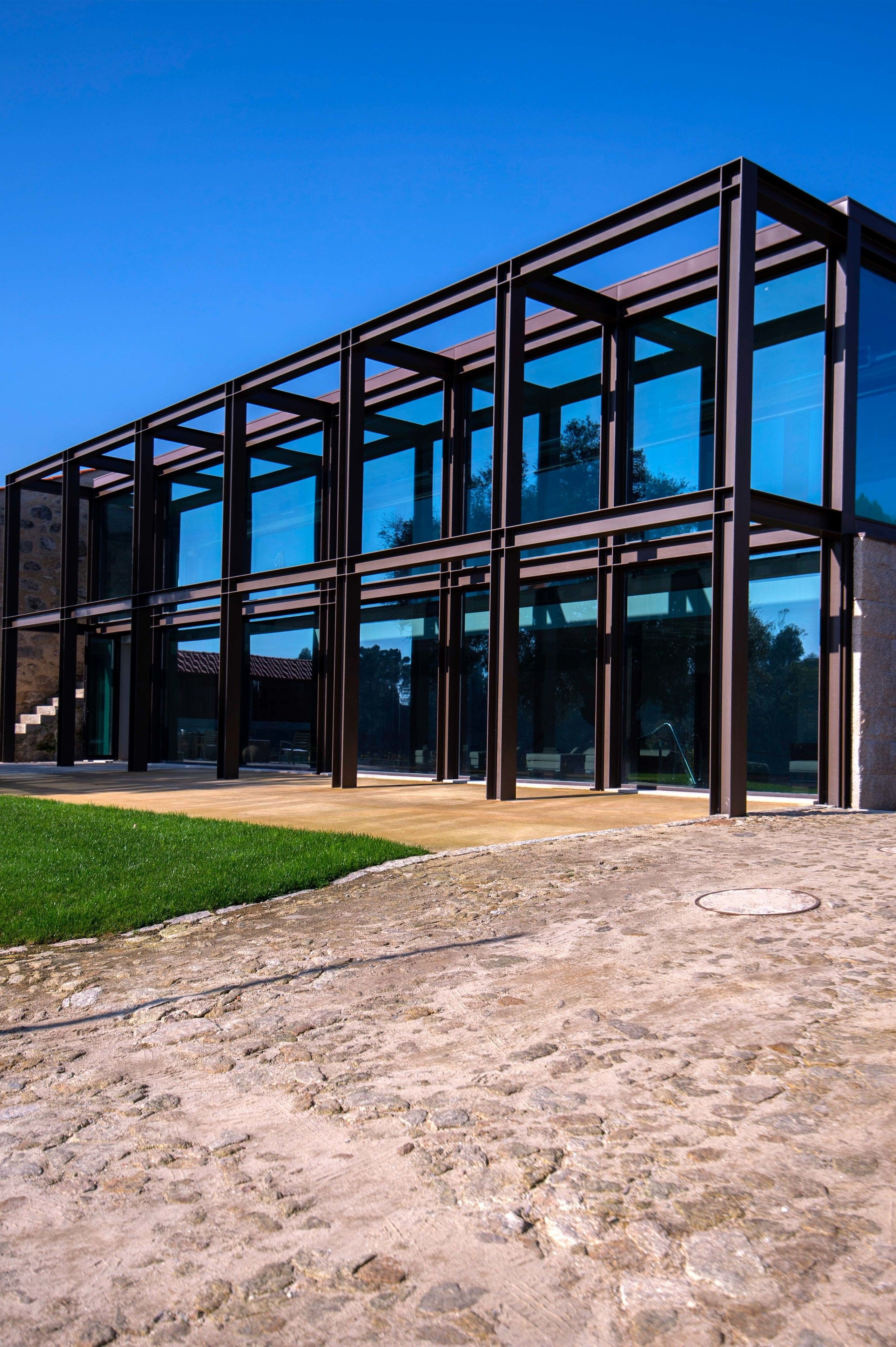 A modern building with a glass facade and a stone foundation.