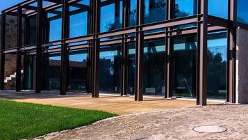 A modern building with a glass facade and a stone foundation.