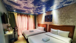 Habitación de hotel con dos camas, un mural en el techo, un cuadro y un televisor en la pared.
