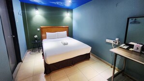 Una habitación de hotel con una cama, un escritorio con teléfono y un espejo.