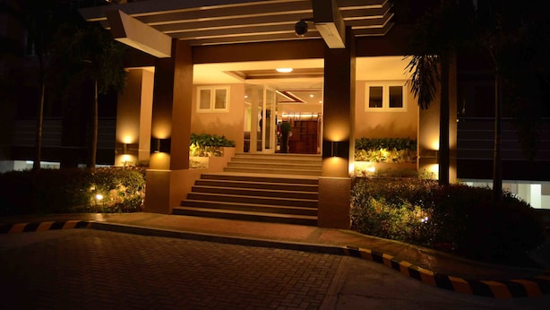 A hotel entrance with steps leading up to a covered area, illuminated by wall-mounted lights. - Stradella Hotel (Pasig)