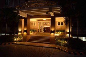 A hotel entrance with steps leading up to a covered area, illuminated by wall-mounted lights. - Stradella Hotel (Pasig)