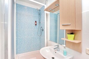 A bathroom with a shower, a sink, and a mirror. - Lucky Home (Rome)