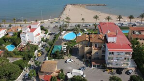 A coastal hotel with a swimming pool, beach access, and multiple parking spaces. - Hotel Subur Maritim (Sitges)