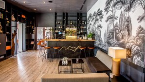 A modern bar area with a wooden counter, bar stools, and a mural of trees on the wall. - Hôtel & Spa des Gorges du Verdon (La Palud-sur-Verdon)