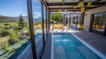 Piscina moderna ao ar livre com vista clara da paisagem circundante, incluindo colinas e árvores.
