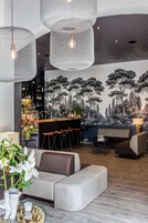 Decoração moderna com área de bar, assentos e um mural.