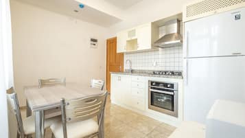 Deluxe Apartment, Kitchen (Large) | Private kitchen | Full-size fridge, oven, stovetop, coffee/tea maker