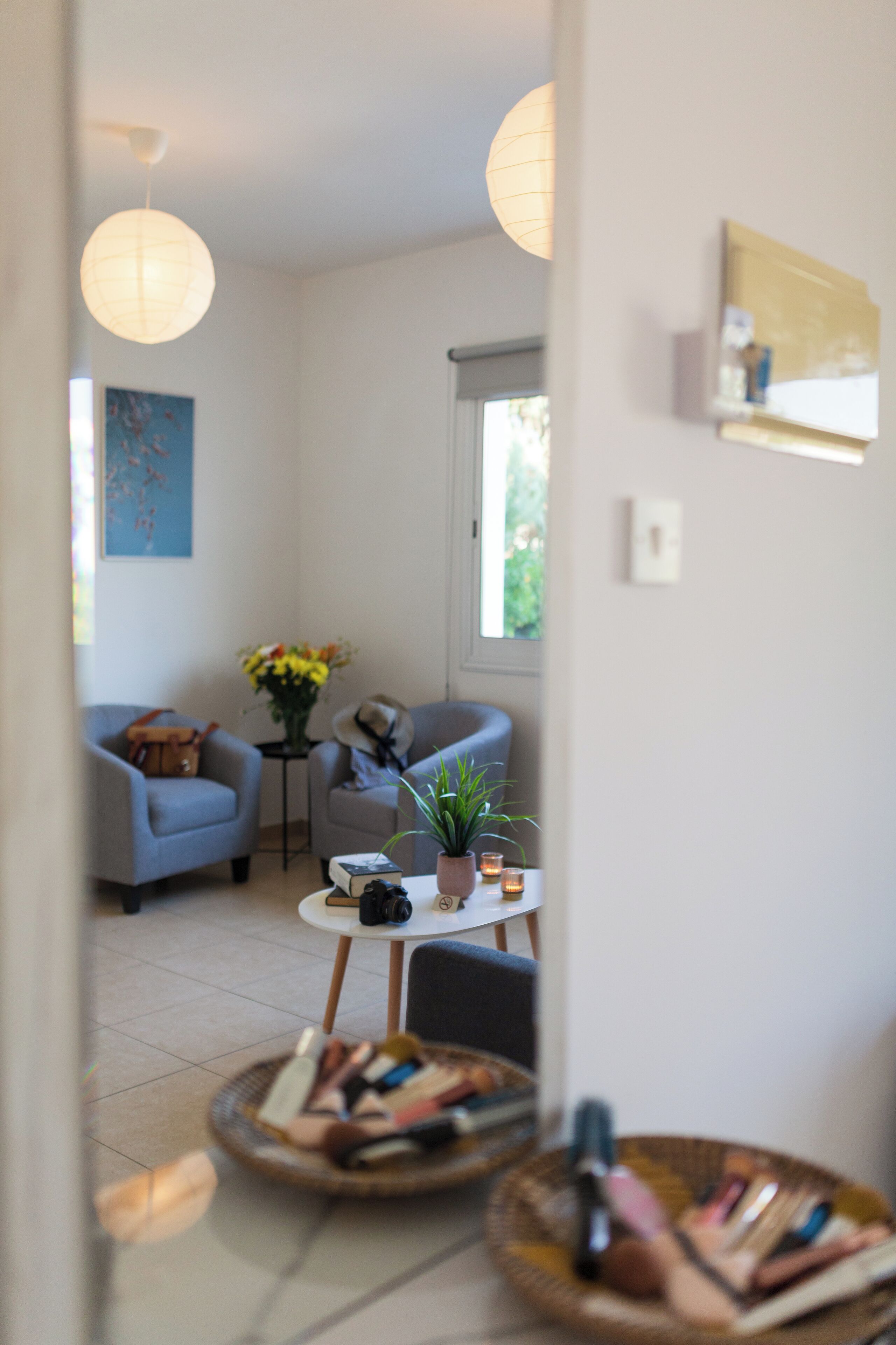 Una sala moderna con sofá, sillones, una mesita de centro y una planta en maceta.