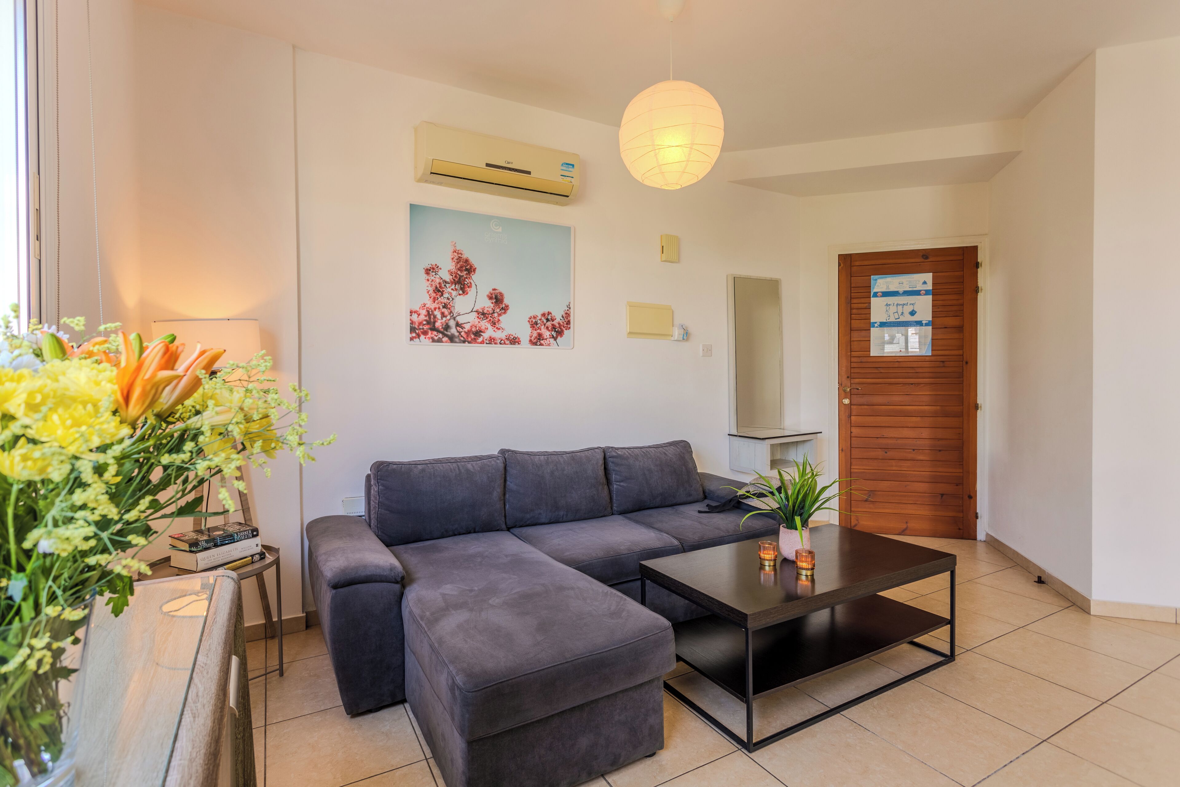 Una sala moderna con un sofá modular, una mesa de centro y un florero con flores.