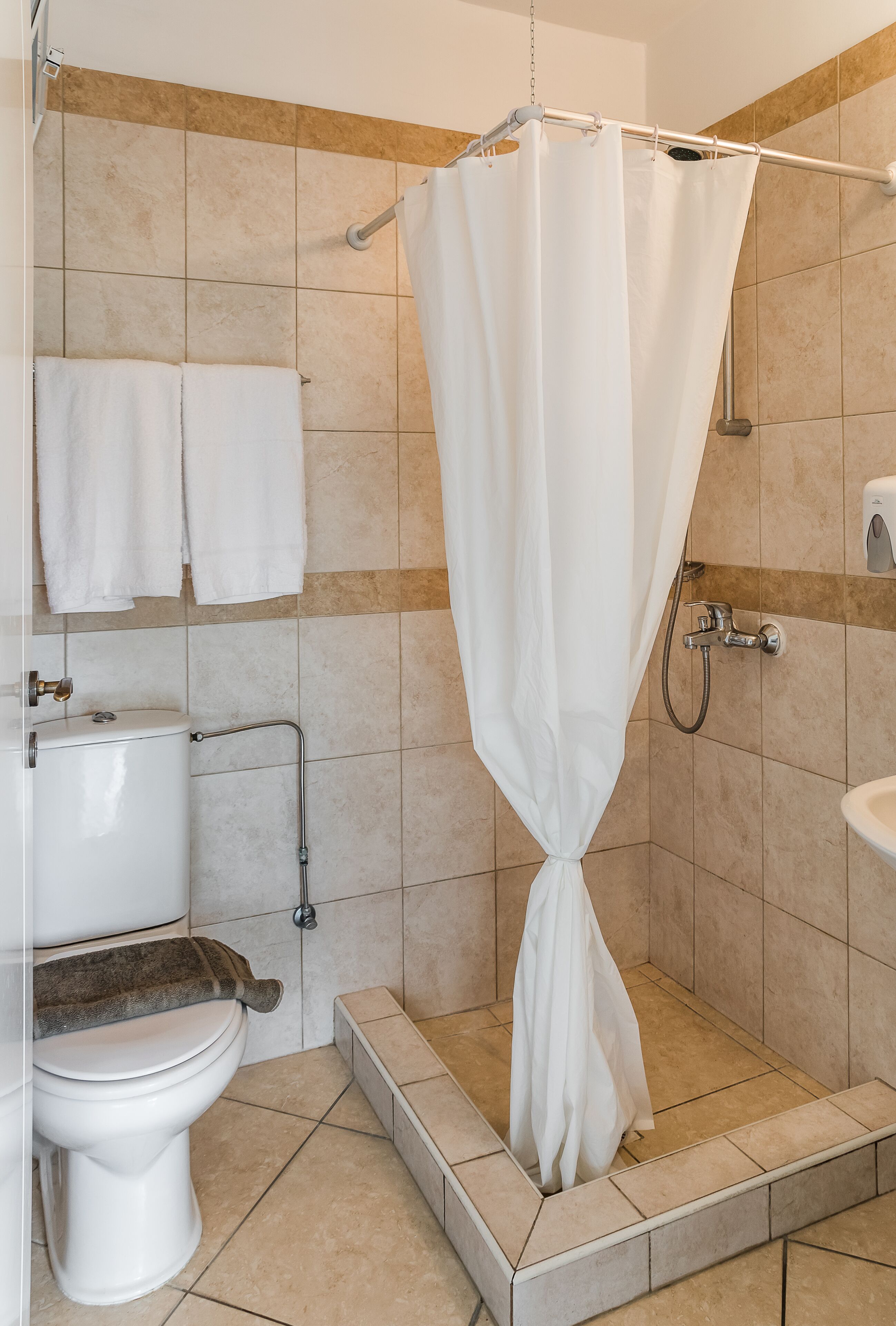 Un baño con ducha, inodoro y lavamanos.