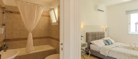 Un baño con bañera, inodoro y lavamanos.