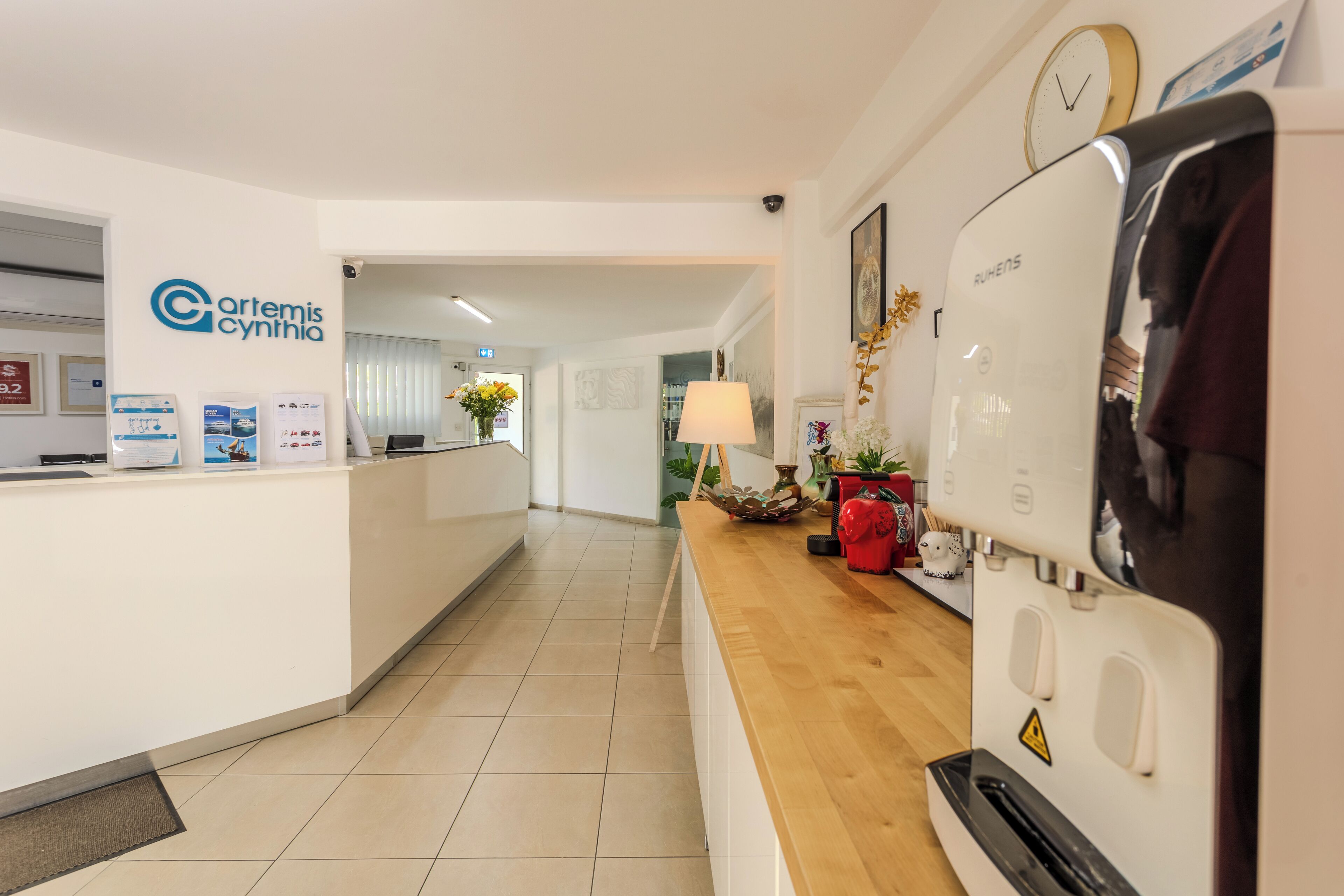 A reception area with a reception desk, a clock, and a coffee machine.