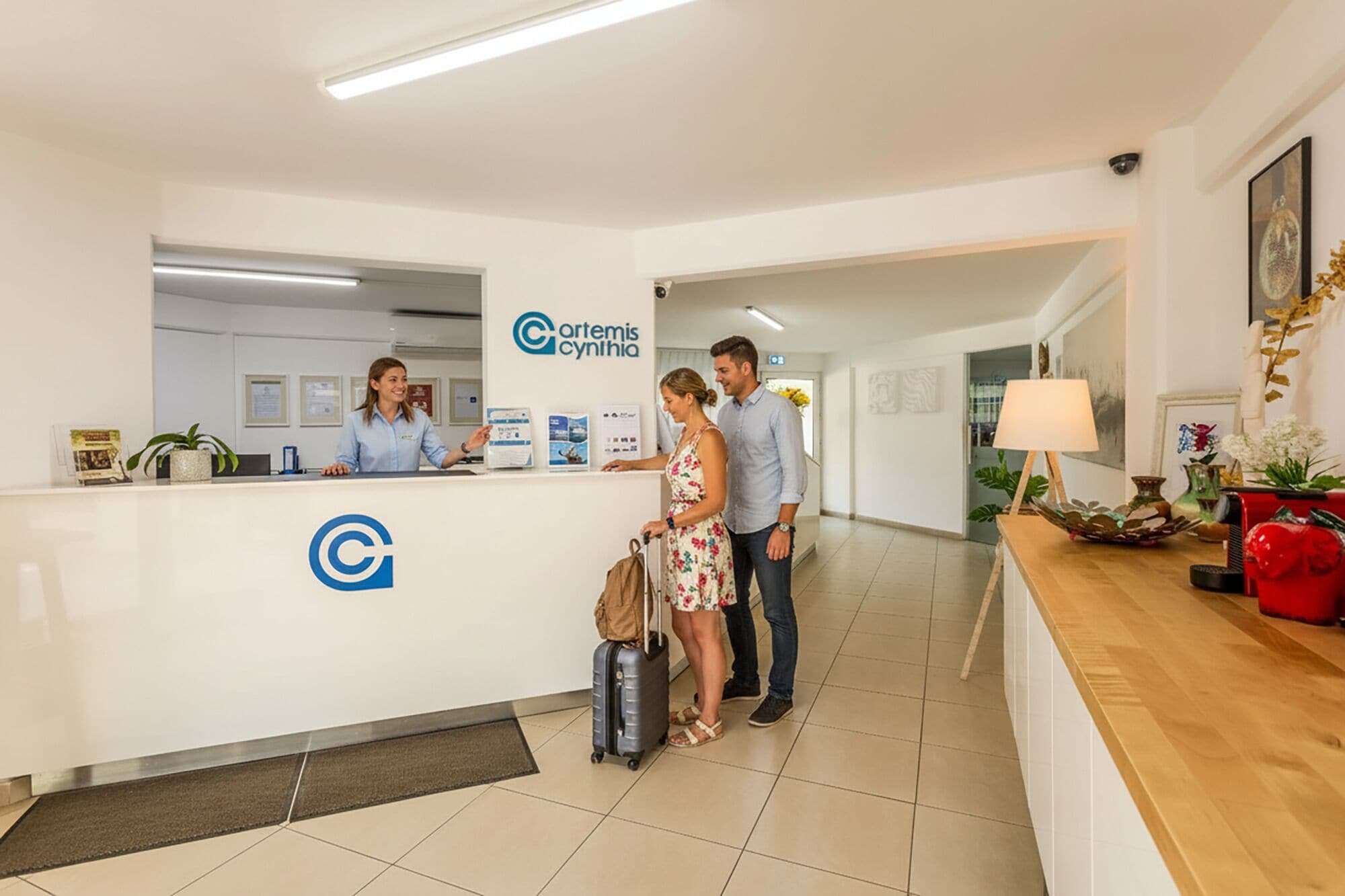 A reception desk with a logo, a waiting area with a wooden counter, and a tiled floor.