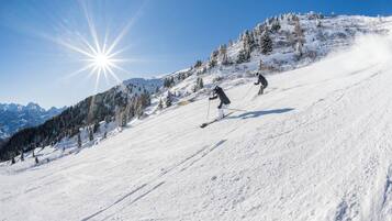 Ein verschneiter Skipisten mit Skifahrern.
