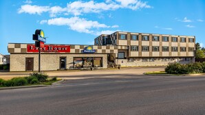Een Days Inn hotel met een restaurant en bar genaamd 'Lake House', met een gevel van natuursteen en een modern gebouw aan de overkant van de straat.