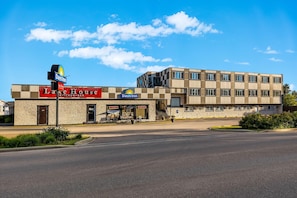 A Days Inn hotel with a 'Lake House' restaurant and bar, featuring a stone facade and a modern building across the street. - Days Inn by Wyndham Sylvan Lake (Sylvan Lake)