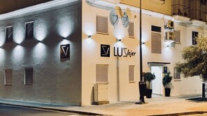 A building with a sign reading "LUVejer" and multiple windows with shutters. - LUZ Vejer Hospedería (Vejer de la Frontera)