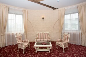 Classic design room with a white brick wall, red carpet, and striped armchairs.