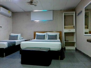 A hotel room with two beds, a bedside table, a wardrobe, and a ceiling fan. - Casa Boston Inn (Barranquilla)