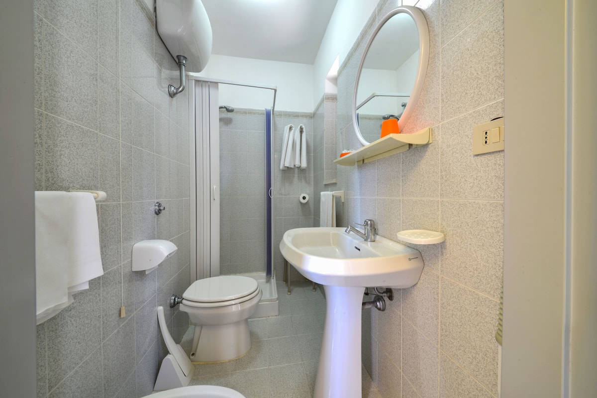 A modern bathroom with a toilet, sink, and shower.