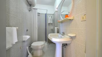 A modern bathroom with a toilet, sink, and shower.