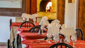 A dining area with tables set for a meal, featuring red tablecloths and white napkins. - Hotel Piccolo Paradiso (Peschici)