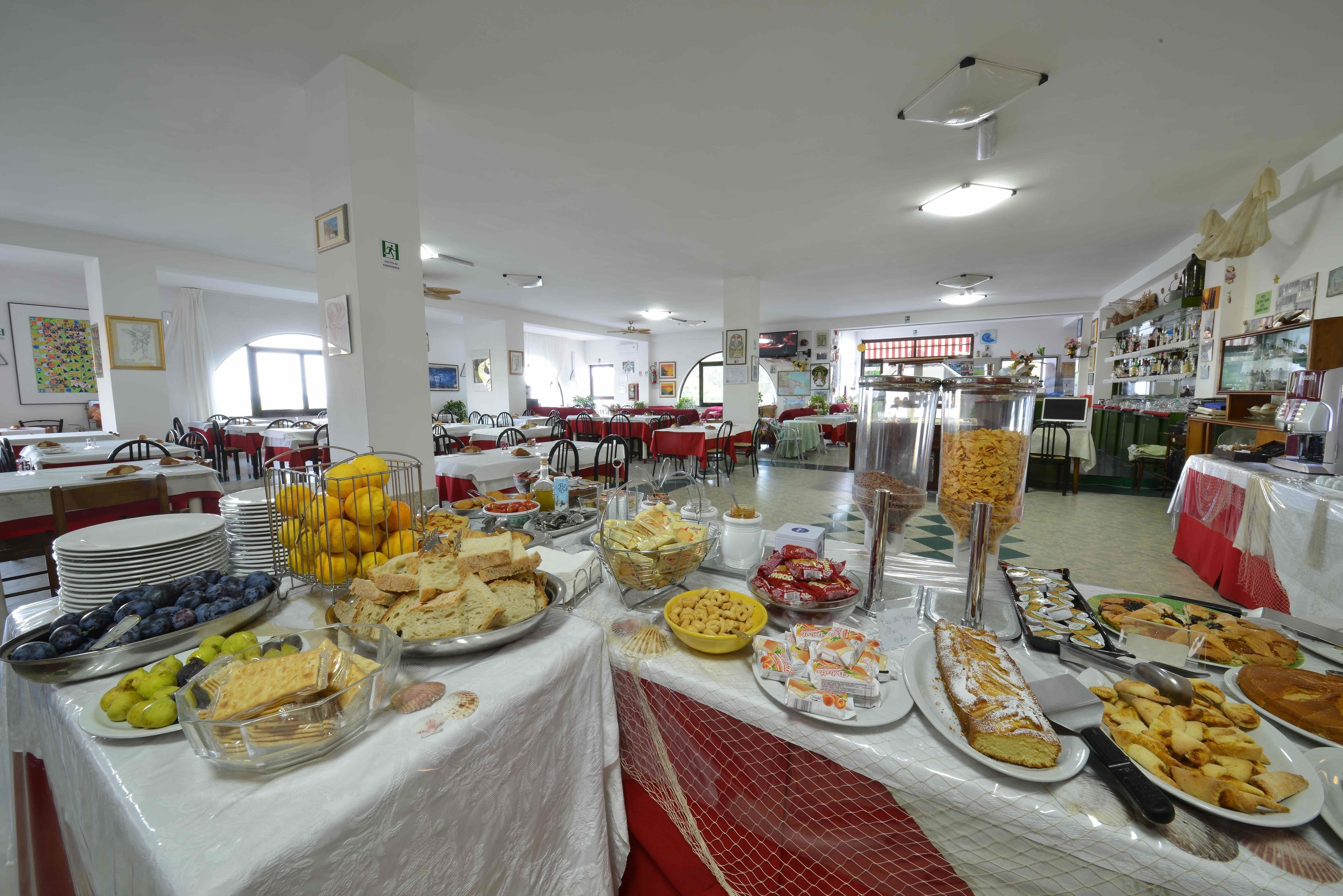 Un montaje tipo bufé con diferentes alimentos y un área de asientos al fondo.