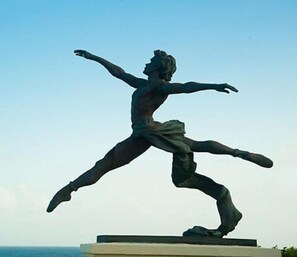 A bronze statue of a dancer on a pedestal. - LeMarida Suites (Speightstown)