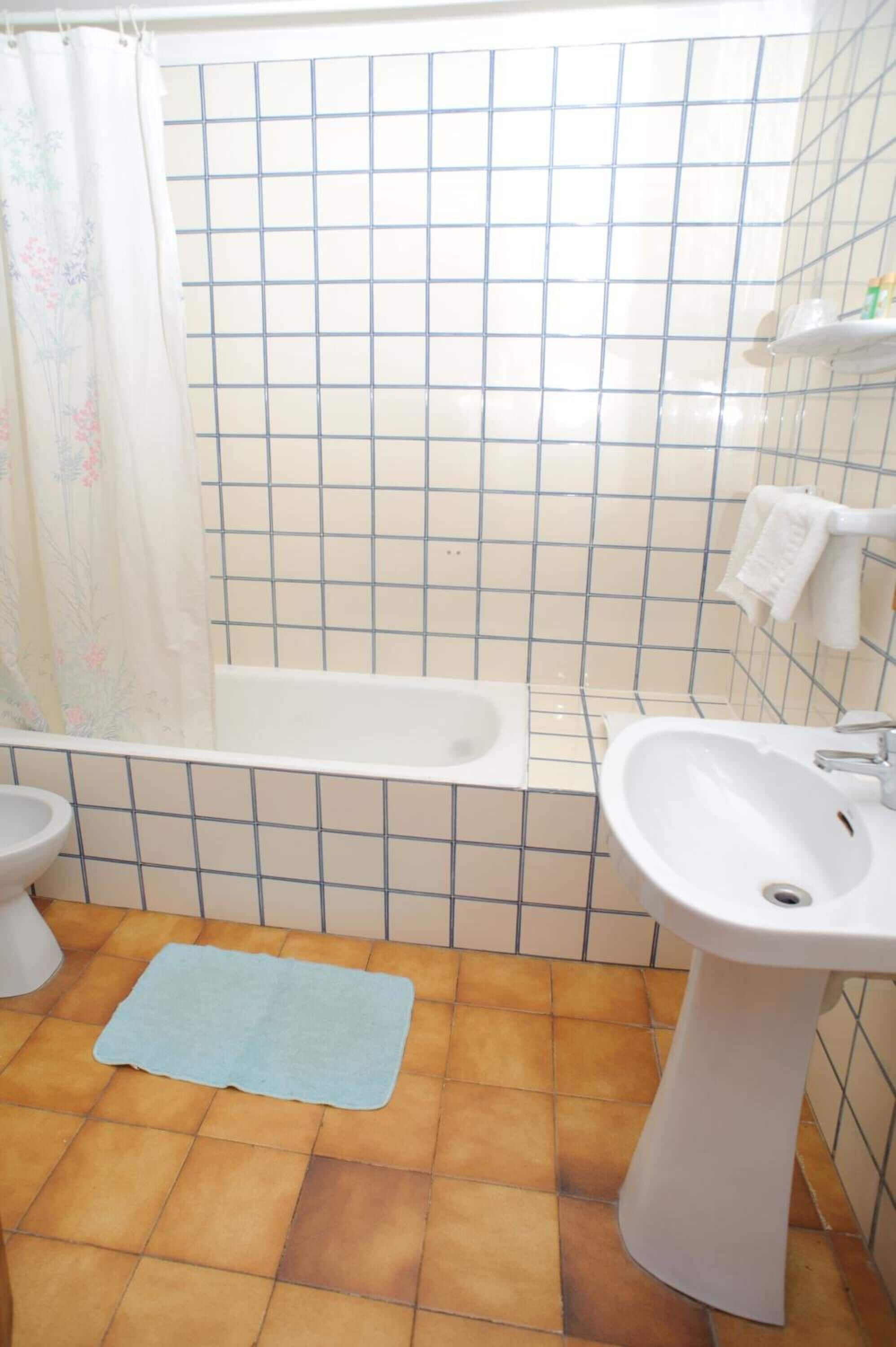 A bathroom with a bathtub, a sink, and a toilet.