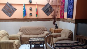 Una sala acogedora con sofá, sillones, una mesita y una planta decorativa.