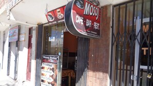 Una cafetería con un letrero que anuncia café de verdad, cappuccino, desayuno, calefacción, hamburguesas y jugos naturales.