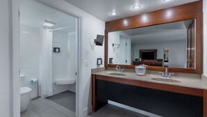 A modern bathroom with two sinks, a large mirror, and a shower area. - Crosswinds Rehoboth  (Rehoboth Beach)