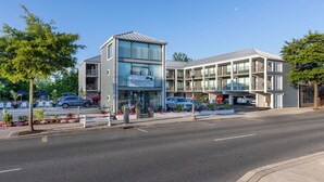 A modern motel with a two-story structure, a visible entrance, and a parking area with several cars. - Crosswinds Rehoboth  (Rehoboth Beach)