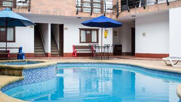 Een binnenzwembad, een buitenzwembad, parasols voor strand/zwembad