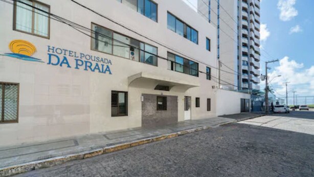 Ein modernes Hotelgebäude mit der Aufschrift "Hotel Pousada da Praia" an der Fassade.