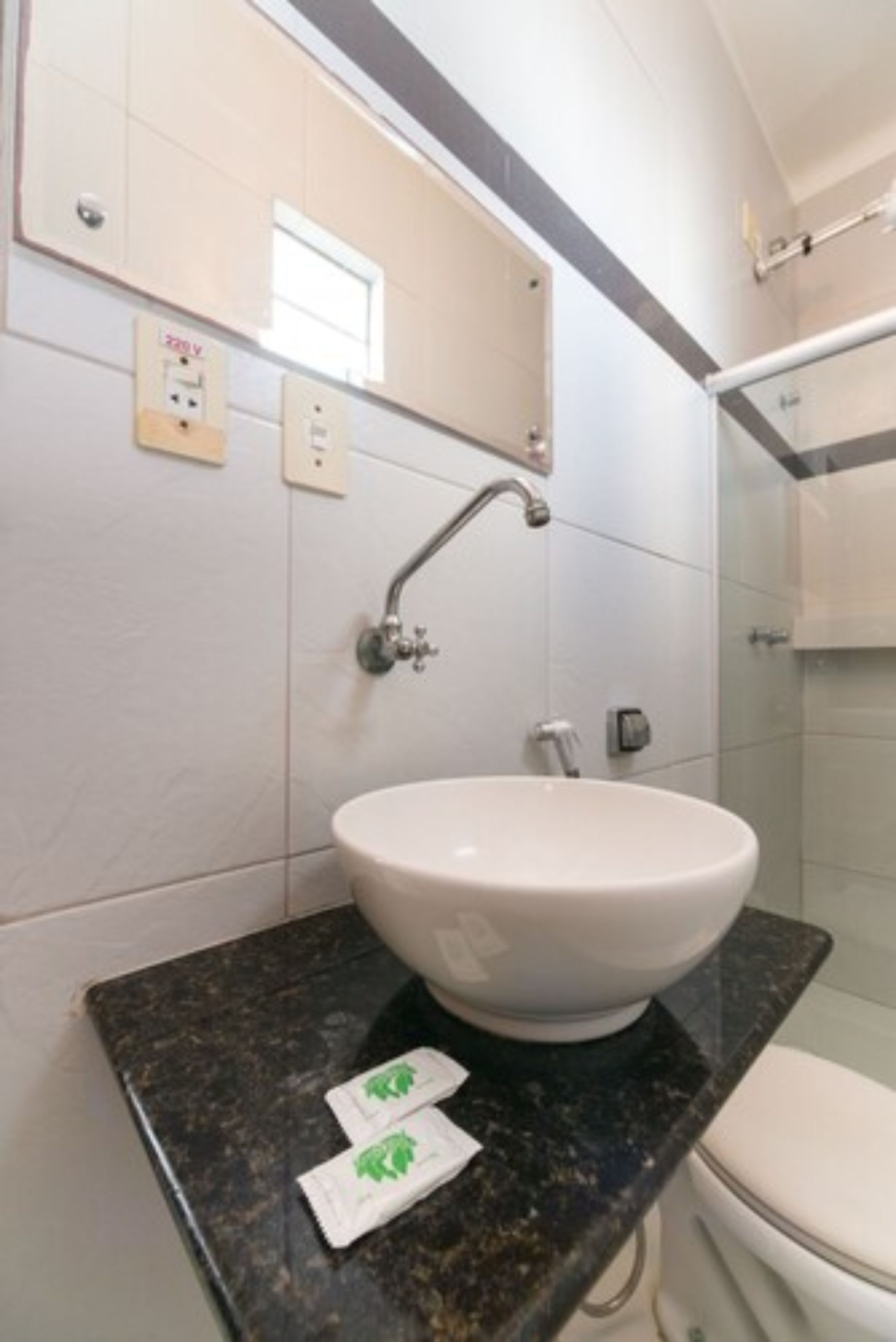Un bagno con lavandino bianco, uno specchio e zona doccia.