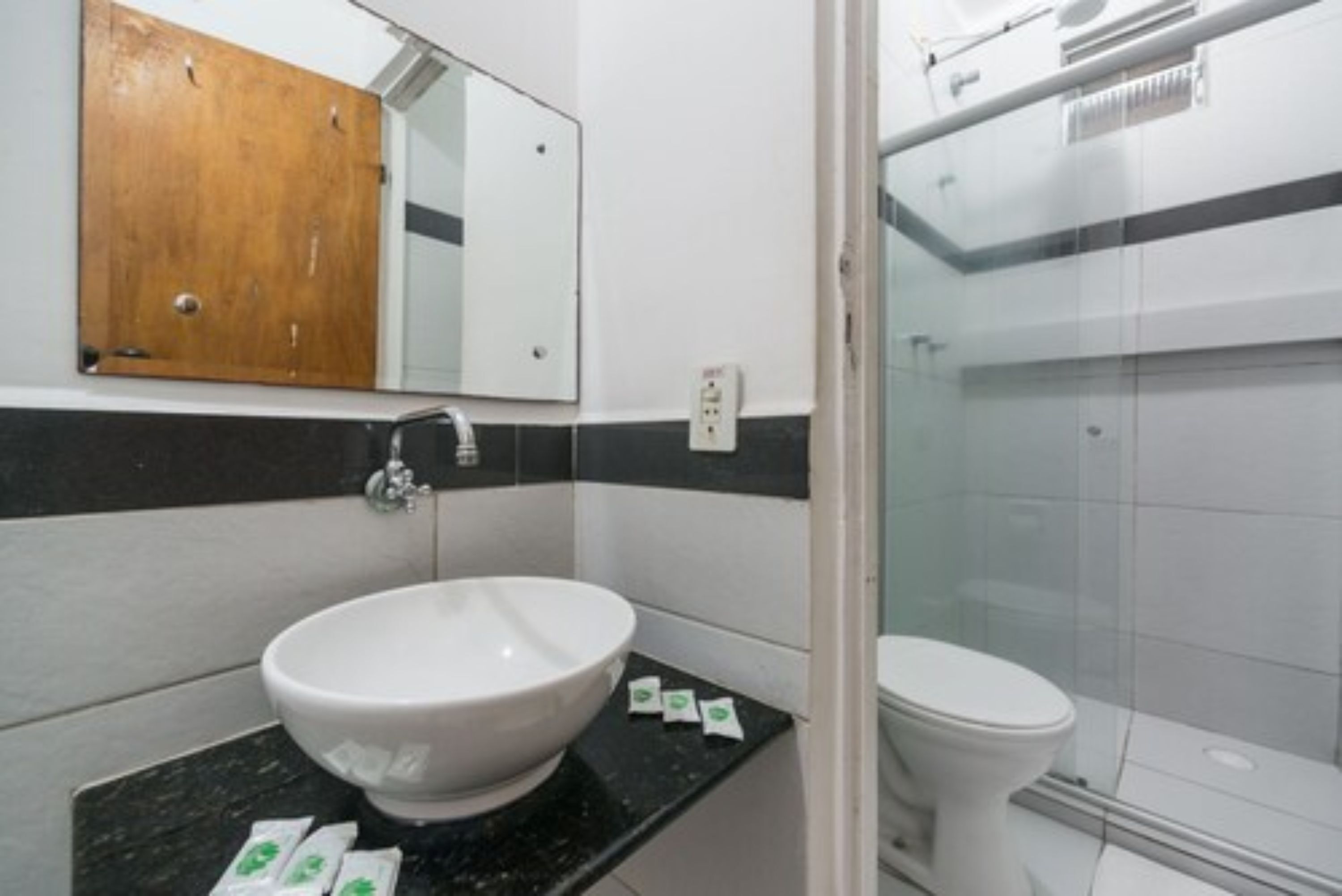 A bathroom with a white sink, a mirror, and a toilet.